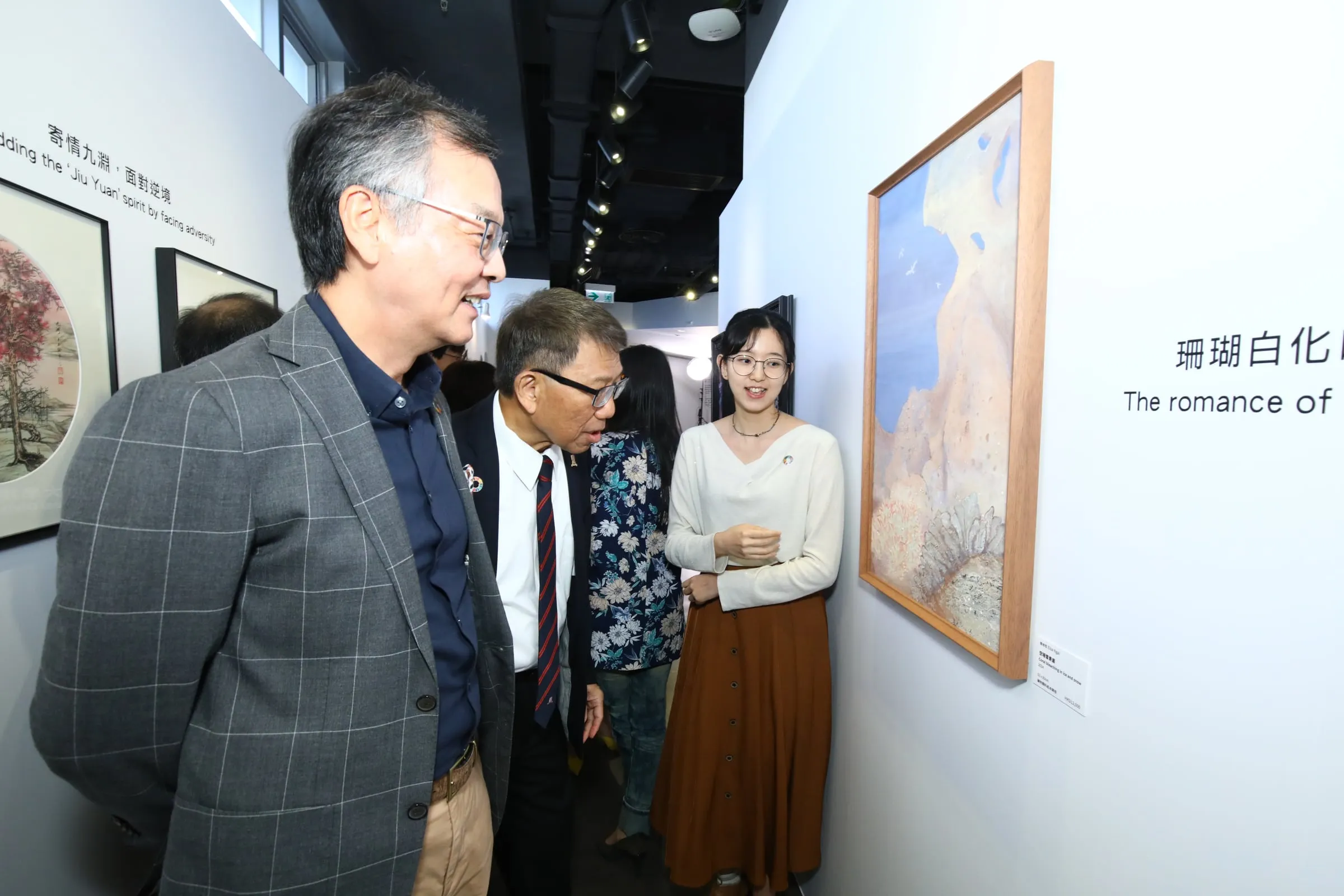 Guests looking at paintings in the anniversary exhibition